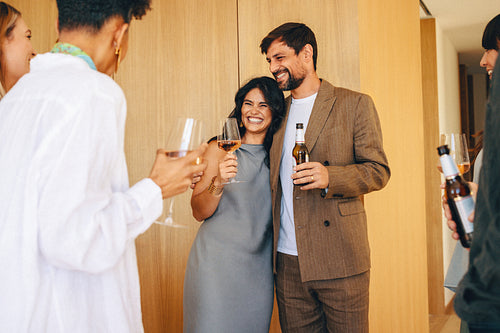 Joyful friends enjoying drinks together at a warm indoor celebration