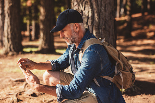 Mature male hiker using digital tablet for navigation
