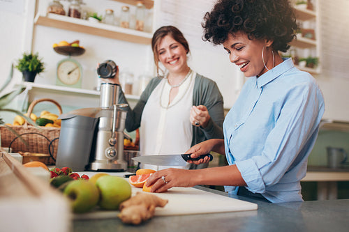 Cheerful young women working at juice bar