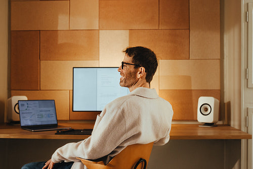 Creative senior man working at his desk with laptop and monitor