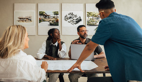 Group of diverse architects discussing project ideas in a creative studio setting