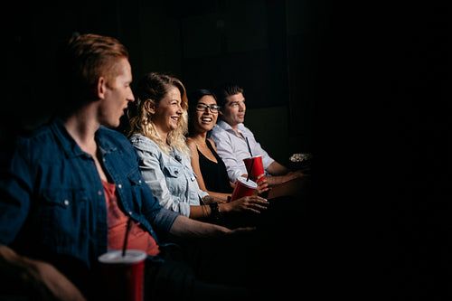 Young people watching movie in cinema.