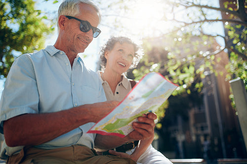 Senior couple together in the city with a map
