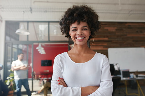 Smiling young woman standing in creative office