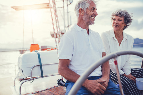 Happy senior couple sitting on the board of yacht