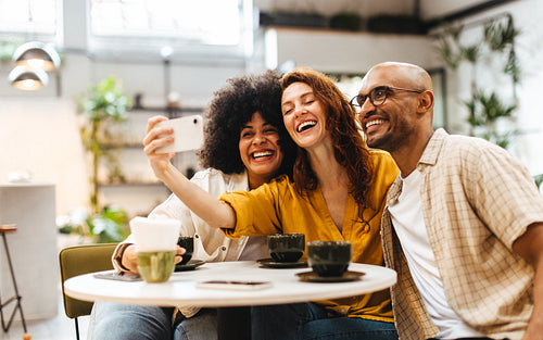 Fun selfie with friends: Group of young people hanging out in a restaurant