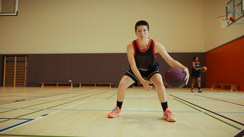 Young athlete practices basketball dribbling