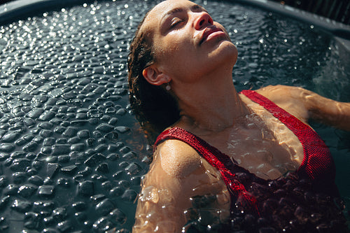 Woman in ice bath recovery session outdoors for cold therapy and wellness