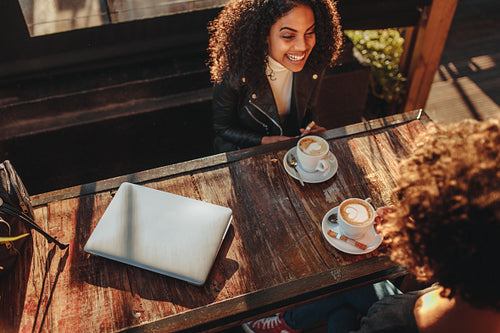 Two women talking over coffee at a coffee shop