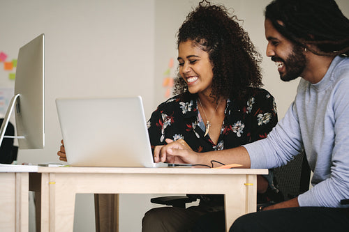 Smiling businessman and woman working together in office