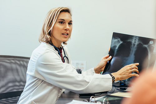 Doctor showing diagnosis of x-ray image to patient