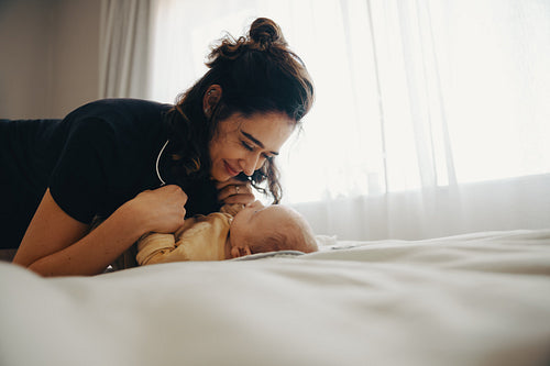 Mother with baby on bed sharing tender moment