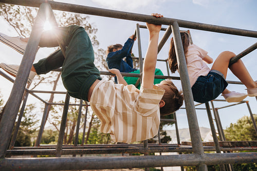 Children climbing on playground equipment on a sunny day outdoors