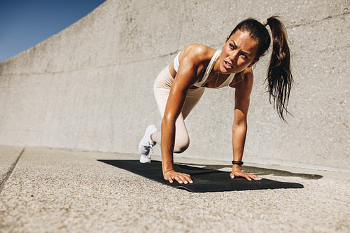 Healthy woman doing mountain climbers exercise