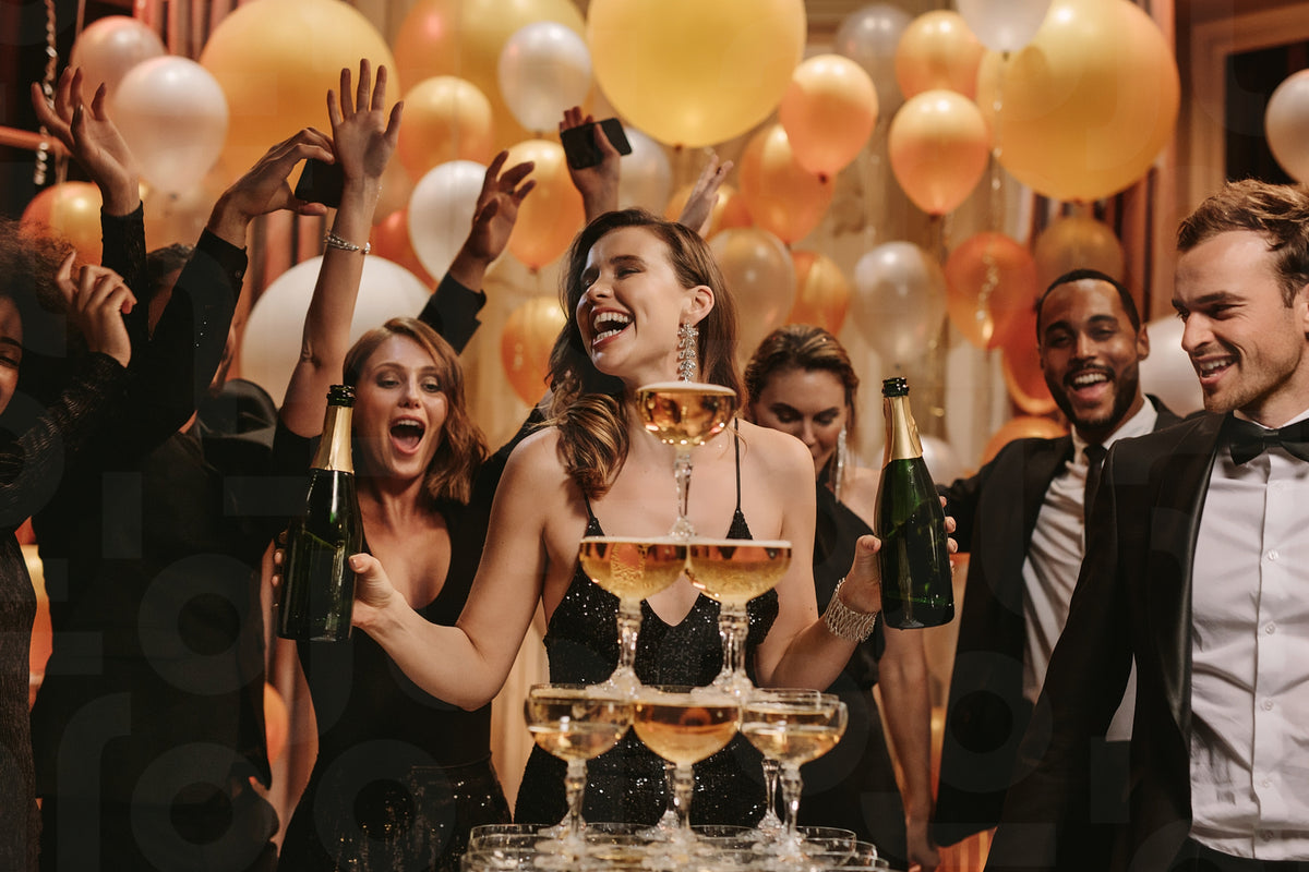 Pyramid of champagne with people dancing around in party – Jacob Lund ...