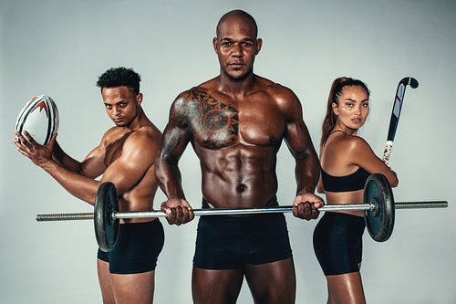 Three young fitness people with sports equipments