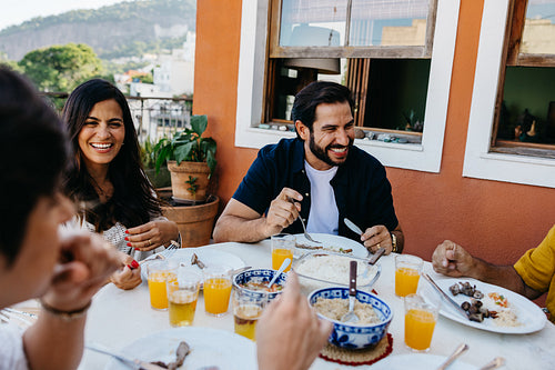Family enjoying traditional Brazilian churrasco on a sunny outdoor terrace