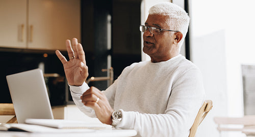 Senior businessman having a virtual meeting at home