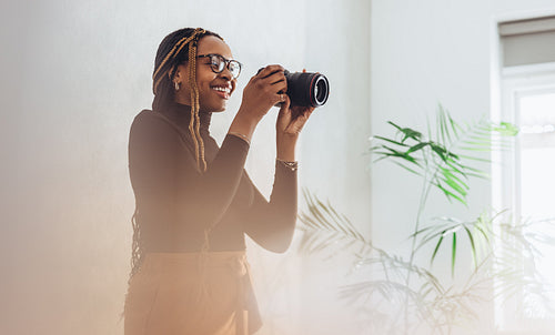 Happy female photographer taking a photo