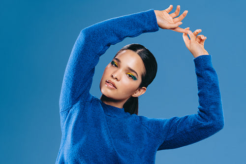 Radiance in portrait: Woman with bold graphic eyeliner looks at the camera in a studio