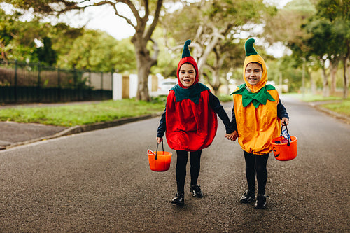 Identical twin girls trick or treating on halloween