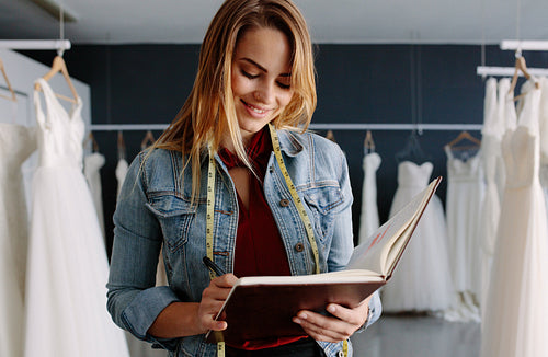 Female bridal store owner with a diary