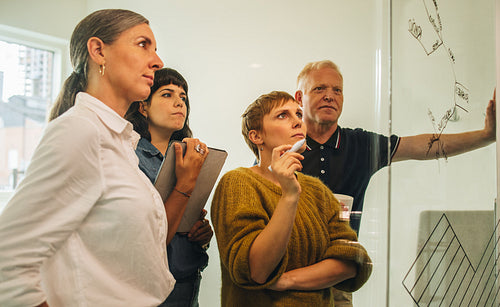 Business team looking at glass wall and thinking