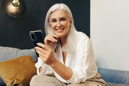 Happy senior woman using her smartphone to stay connected in retirement