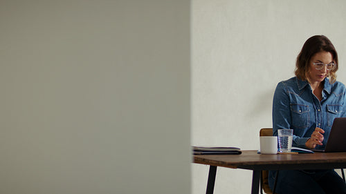 Business professional woman working on laptop at office desk