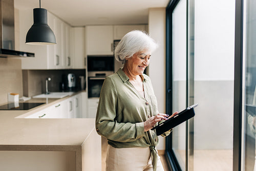Happy senior woman using a digital tablet at home