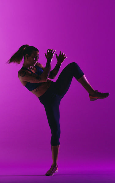 Fit woman working out on purple background