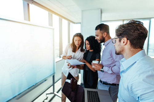 Entrepreneurs discussing business ideas in boardroom. 
