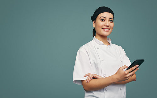 Successful culinary chef using a smartphone in a studio