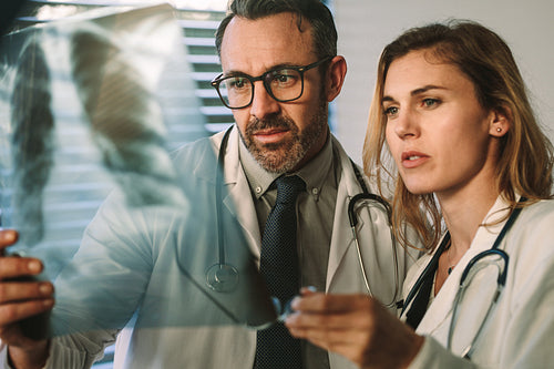 Doctor and surgeon closely studying x-ray of patient