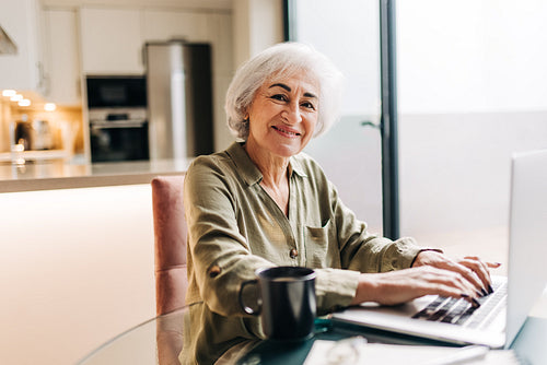 Grey-haired senior businesswoman working in her home office