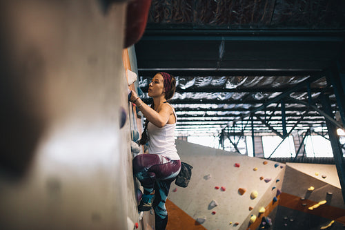Woman climbing indoor boulder wall