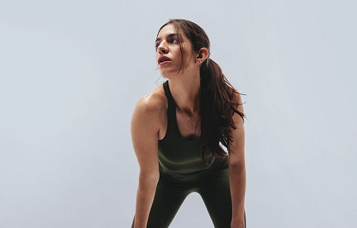 Woman leaning forward after intense fitness workout in studio