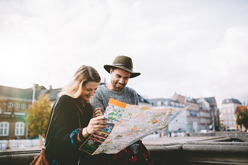 Young tourist couple looking at a navigational map.