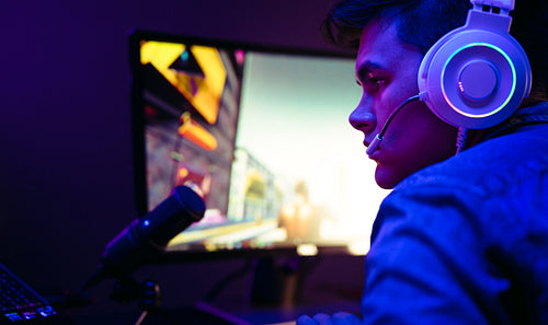 Video game player broadcasting his gameplay to a virtual audience using a microphone