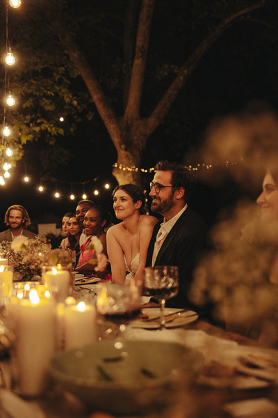Elegant evening wedding reception with guests dining under string lights