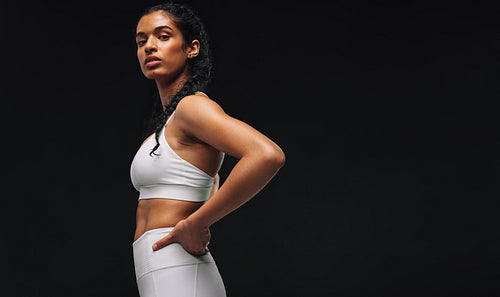 Side view portrait of fit woman on black background