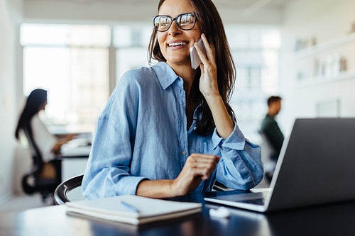 Female business professional making a phone call in an office