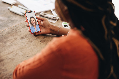 Young woman taking a video call at her office desk