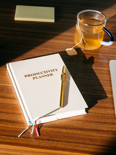 Planning with a planner and tea in an organized desk workspace