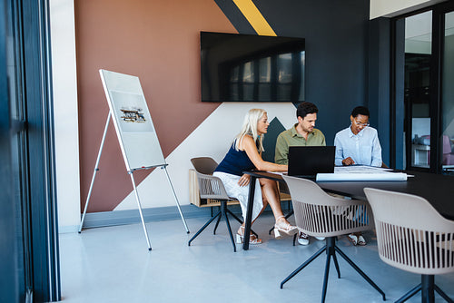 Colleagues reviewing documents together in a modern conference room