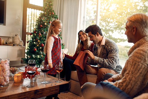 Young man opening christmas gifts from her daughter