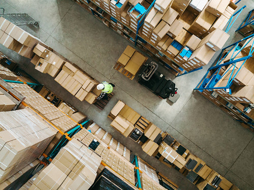 Top view of a warehouse employee moving goods in a logistics centre