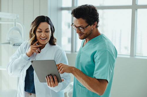Dental team reviewing tablet during healthcare consultation in a modern clinic