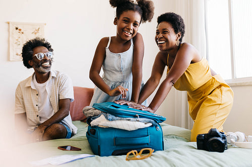 Excited family packing a suitcase for a fun vacation