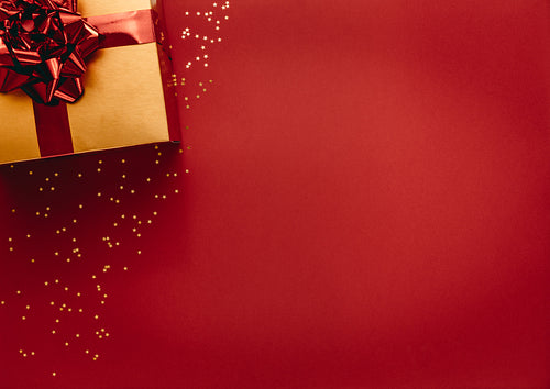 Golden coloured gift box with stars on red background